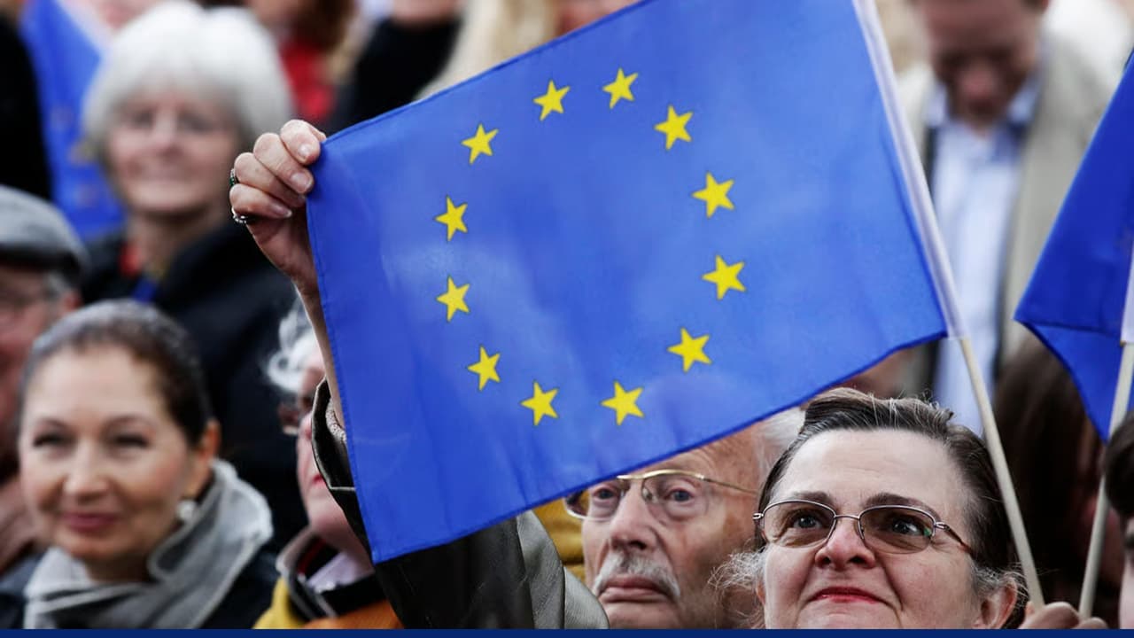 Crowd holding European Union flag during public political gathering